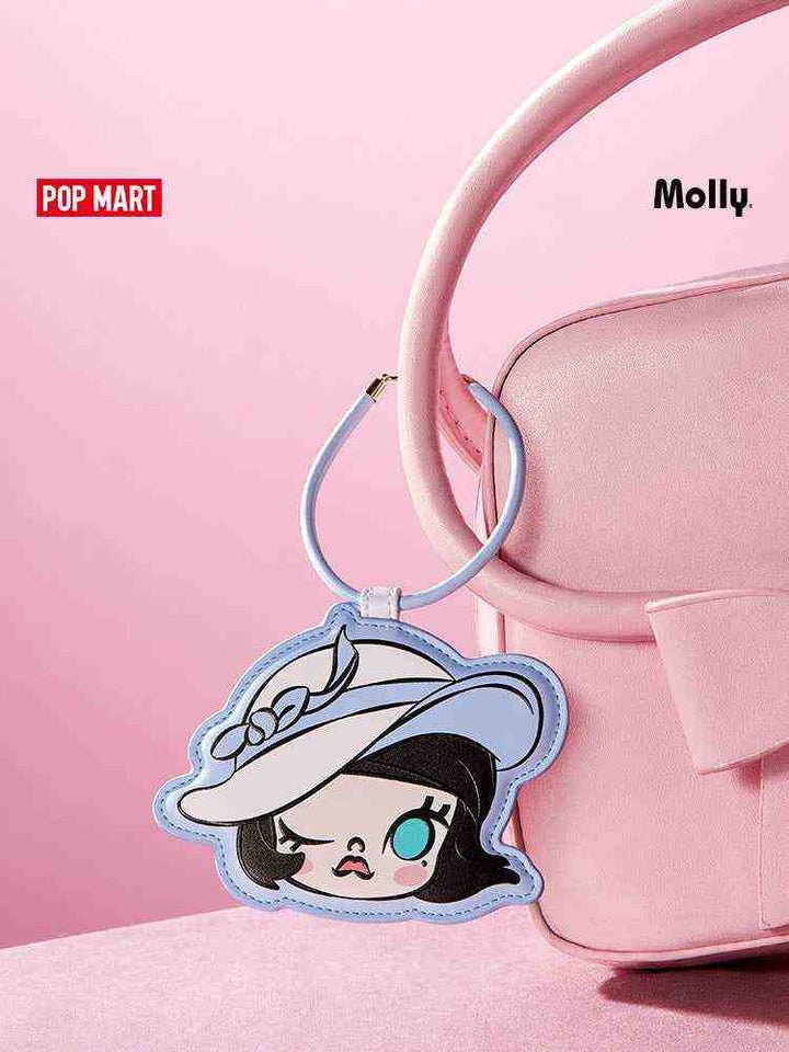 حامل بطاقات Molly بتصميم شخصية كرتونية لطيفة من Pop Mart على حقيبة وردية.