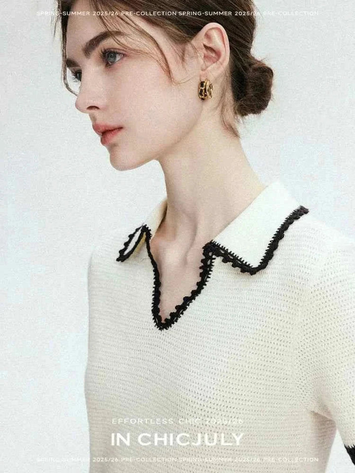 White CHICJULY blouse with black contrasting trim on collar and sleeves, elegant V-neck design, made from wool and natural linen blend.