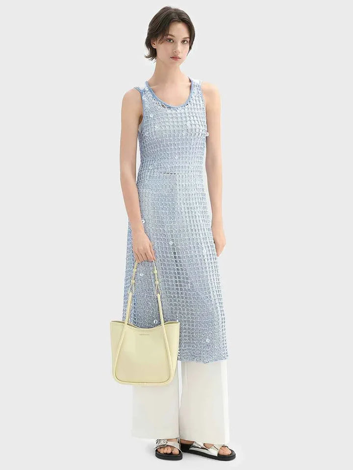 woman wearing blue sleeveless dress and white pants holding yellow CHARLES & KEITH shoulder bag