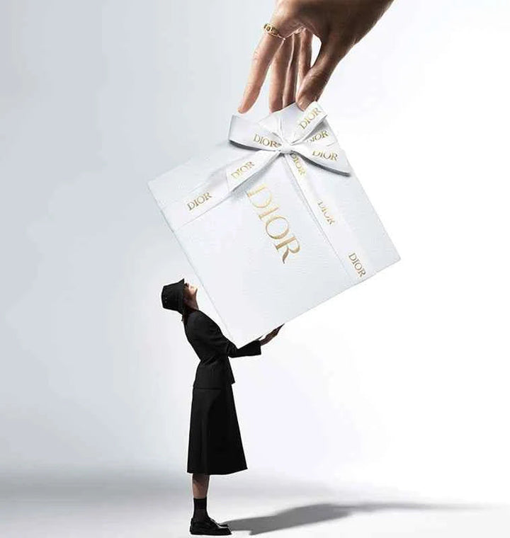 Luxurious Dior Forever Foundation gift box with elegant white and gold design held by a person in black outfit, symbolizing radiant and long-lasting makeup.