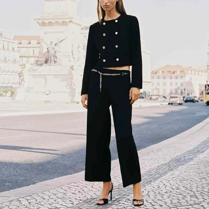 woman wearing black European and American style jacket with gold buttons and chain belt trousers on city street