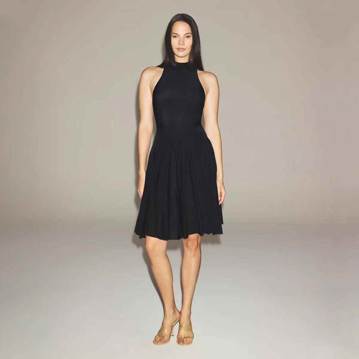 SKIMS black high neck midi dress with sleeveless design and wide flowing skirt on model