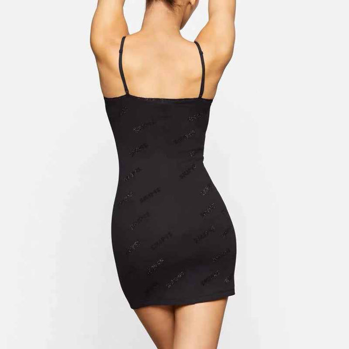 Black short Skims dress with thin straps and subtle logo print, designed for comfort and style.