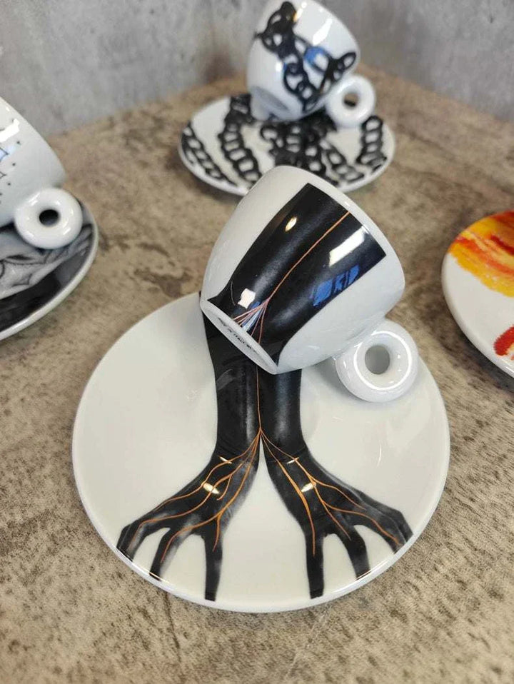 فناجين إسبريسو من illy 2024 مزينة بنقوش فنية باللونين الأسود والبرتقالي مع صوانٍ مطابقة ومقبض دائري مريح من البورسلان اللامع