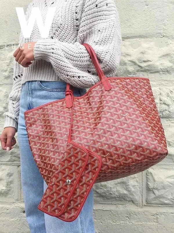 red geometric patterned hobo bag حقيبة كتف with leather strap and matching pouch held by person in knit sweater and jeans