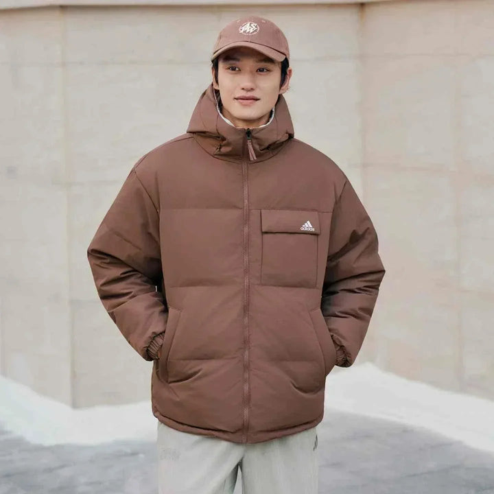 رجل يرتدي Adidas جاكيت 600 Puff بني دافئ مع قبعة في الهواء الطلق