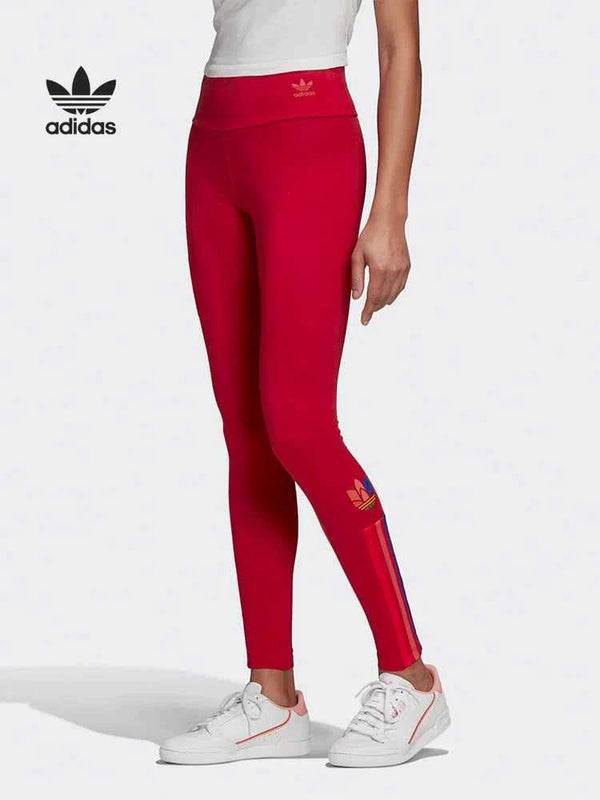 Red Adidas leggings with colorful side stripes, flexible and comfortable fit, ideal for sports and casual wear.