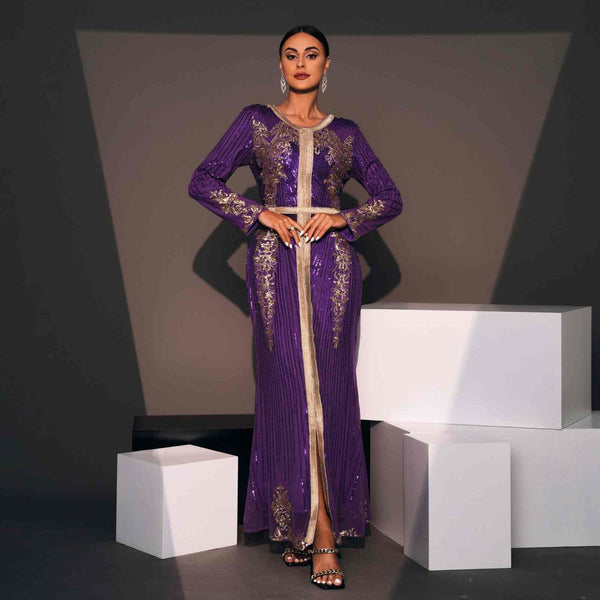 Luxurious Moroccan purple caftan with gold embroidery and shiny fabric, ideal for special occasions.