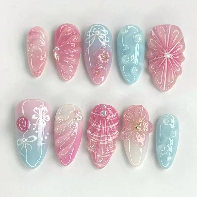 أظافر تركيب Press-on Nails بتصميم زهور بارزة وألوان وردية.