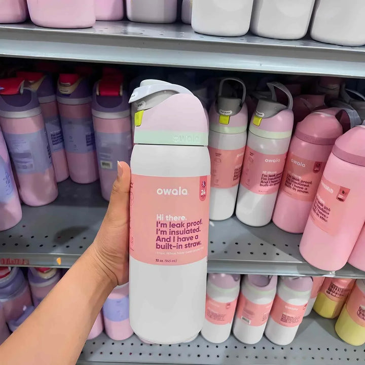 Owala FreeSip pink and white leak-proof insulated water bottle with built-in straw on store shelf