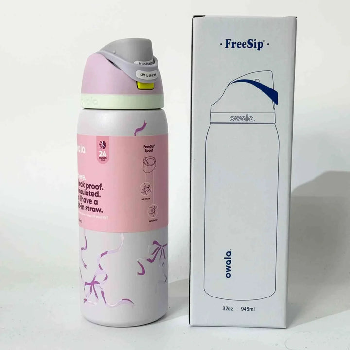 Owala FreeSip pink stainless steel water bottle with dual sip spout and leak-proof design next to its white packaging box