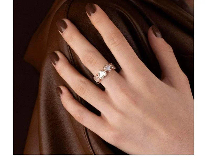 APM Monaco خاتم ذهبي وردي بشكل قلب مرصع بعرق اللؤلؤ الوردي والزركونيا مكعبات بيضاء على يد امرأة