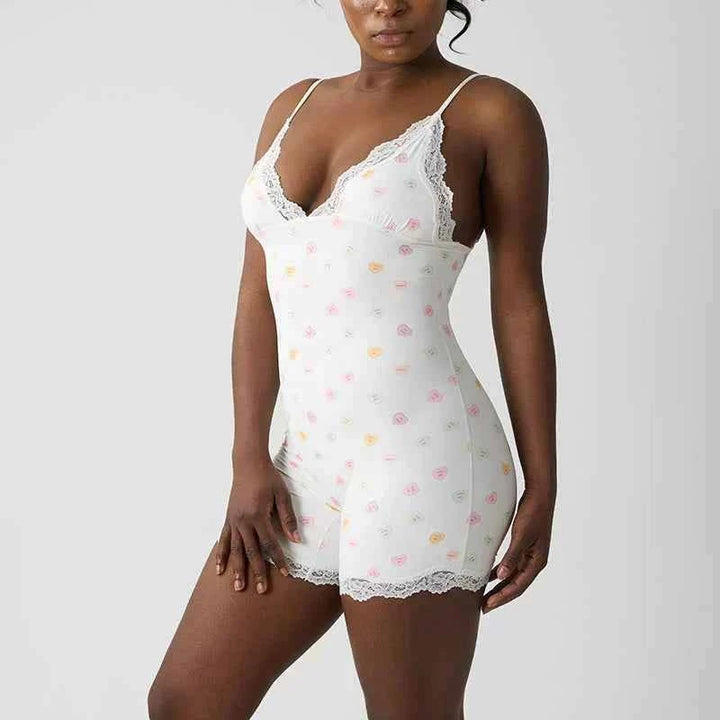 White lace bodysuit with soft floral and heart prints, adjustable straps, and delicate lace trim for a feminine look