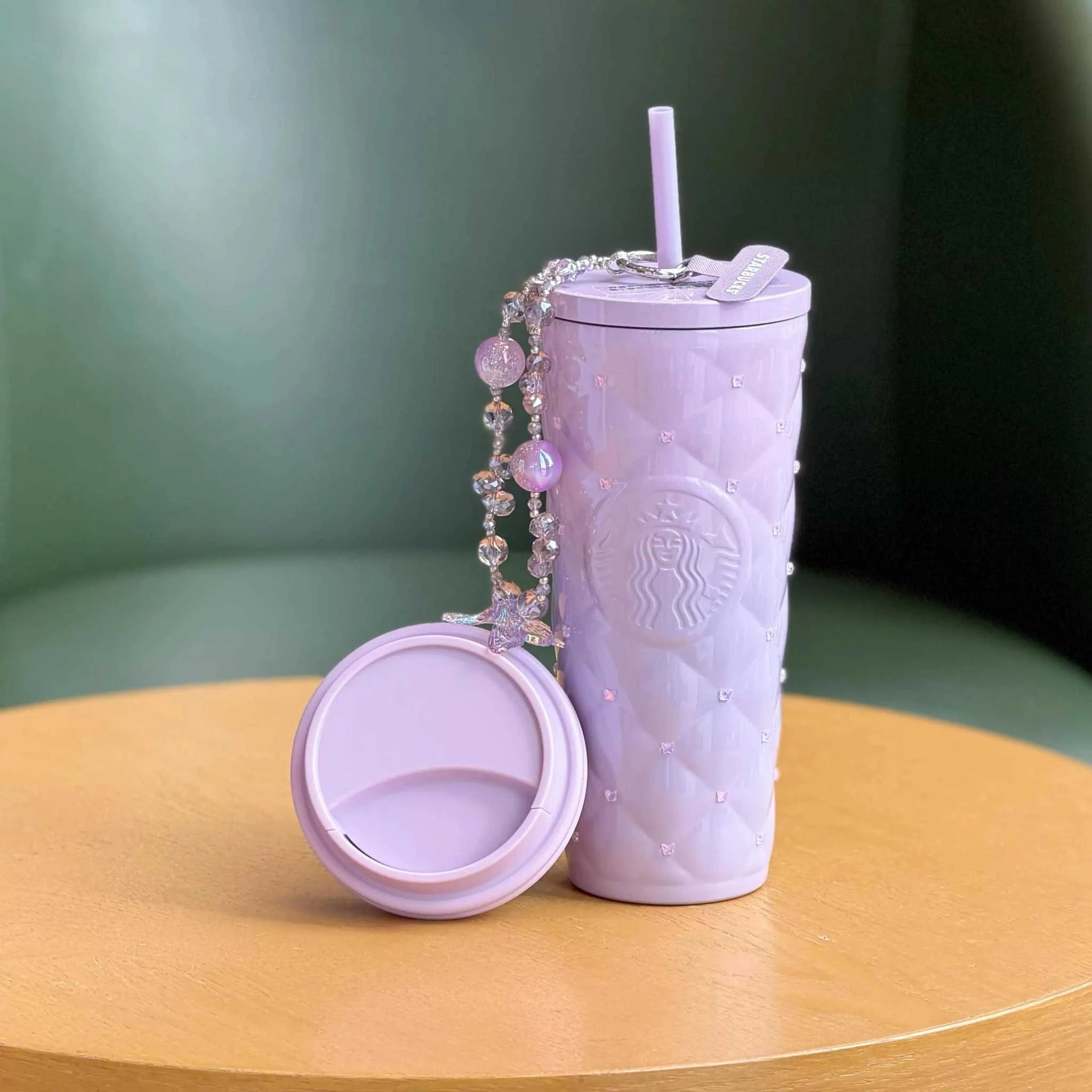 كوب Starbucks بنفسجي مرصع مع تعليقة أنيقة وغطاء إضافي.