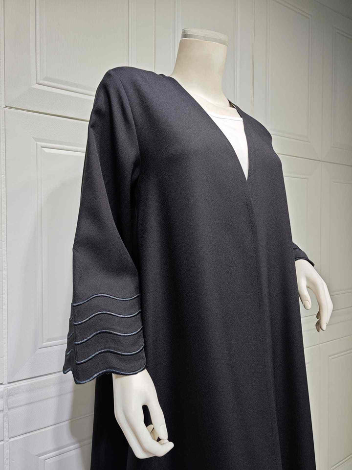 Exquisite black abaya with elegant wavy lines on sleeves, luxurious fabric, and matching hijab, suitable for Autumn 2023.