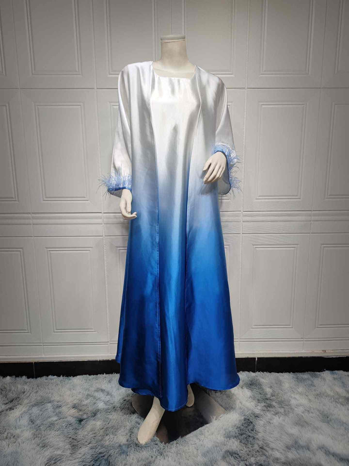 Elegant satin ombre abaya with feathered sleeves, featuring a gradient from white to vibrant blue, perfect for sophisticated fashion tastes in the Middle East and beyond.