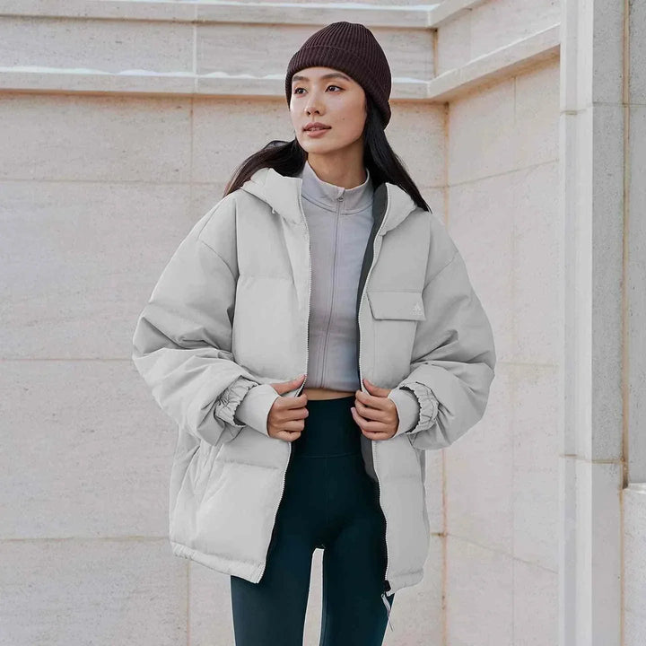 امرأة ترتدي Adidas جاكيت 600 Puff دافئ كاجوال بلون رمادي مع قبعة بنية