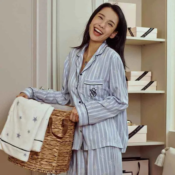 Woman wearing Victoria's Secret star staycation striped soft Tencel long sleeve loungewear pajamas holding a star print blanket
