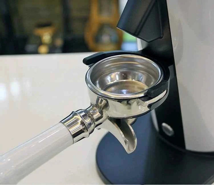 Close-up of a portafilter attached to the DF64N coffee grinder, showing metal grinding components and sturdy design.
