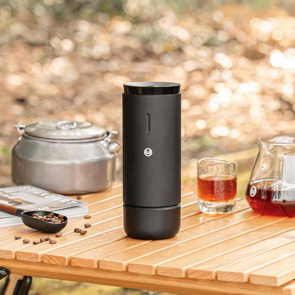 طاحونة تايمور TIMEMORE WHIRLY 01S electric coffee grinder on wooden table with coffee beans and brewing accessories outdoors