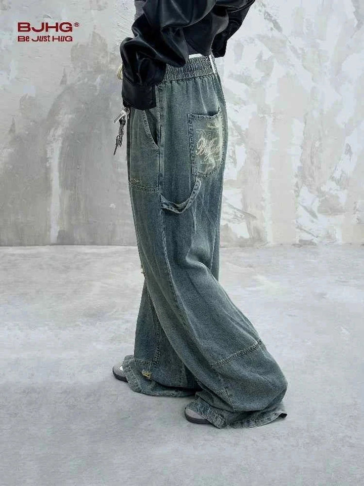 Wide street-style denim jeans with faded wash and heavy denim threads, featuring loose fit and deep pockets for a rebellious urban look