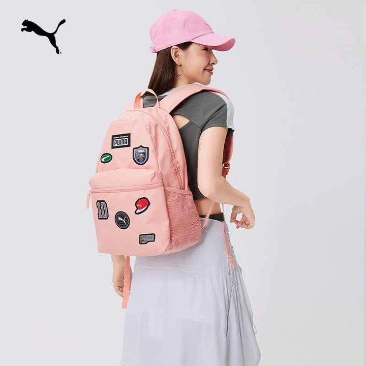Pink PUMA backpack with patches worn by a woman, stylish and practical for school and casual use