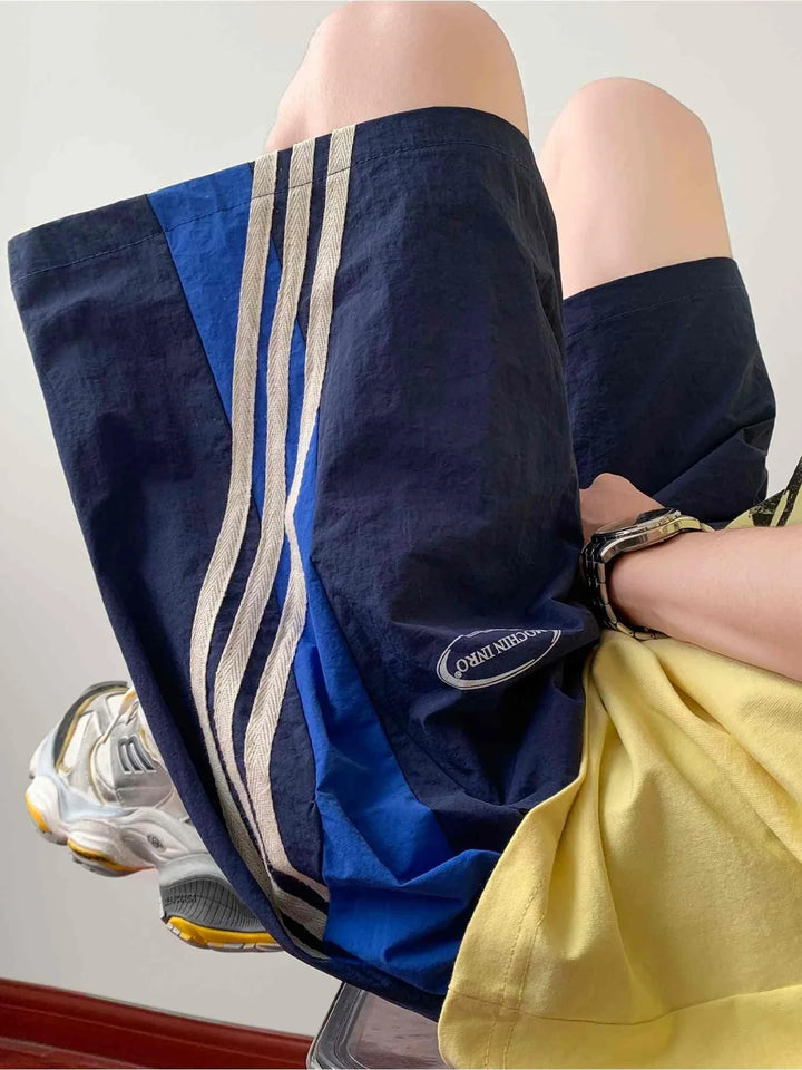 blue and beige side striped sports shorts with adjustable waistband and printed logo