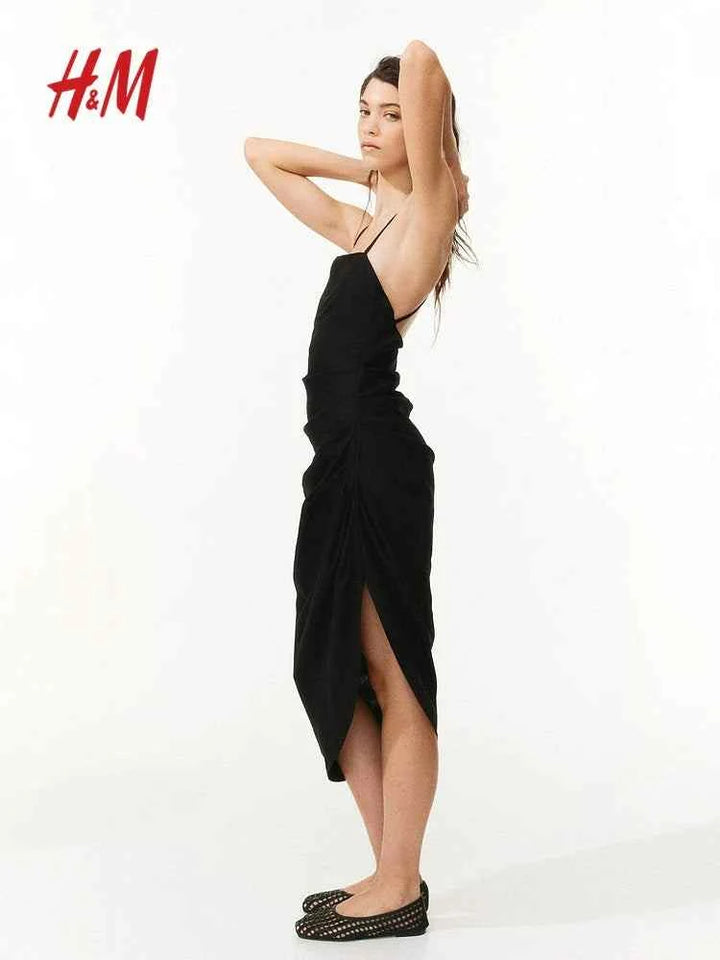 H&M black linen blend midi dress with square neckline and asymmetrical hem, featuring thin cross-back straps.