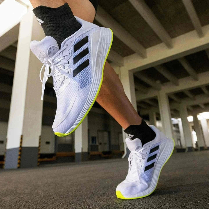 Adidas أديداس حذاء DURAMO SL شبكي للجري بتصميم أبيض بثلاث خطوط سوداء ونعل أبيض لمسات صفراء فيسفورية