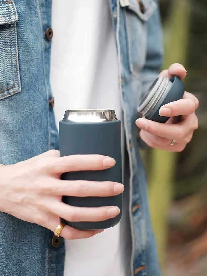 Fellow Carter thermal mug with spill-proof lid being held outdoors.