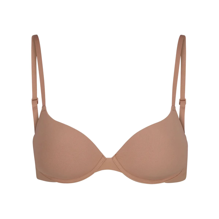 Soft supportive multicolor bra with seamless design and adjustable straps by SKIMS in beige tone.