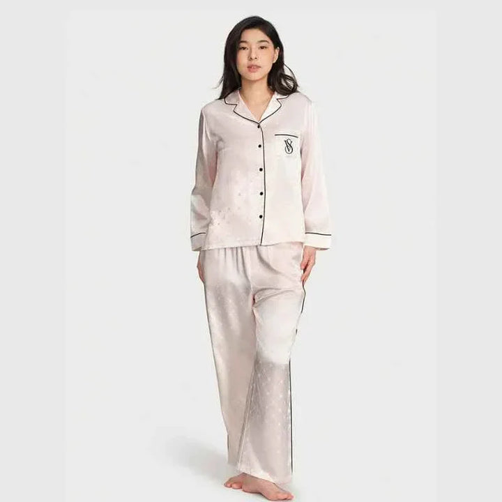 woman wearing Victoria's Secret star staycation satin silk loungewear set with long sleeves and pants in light pink