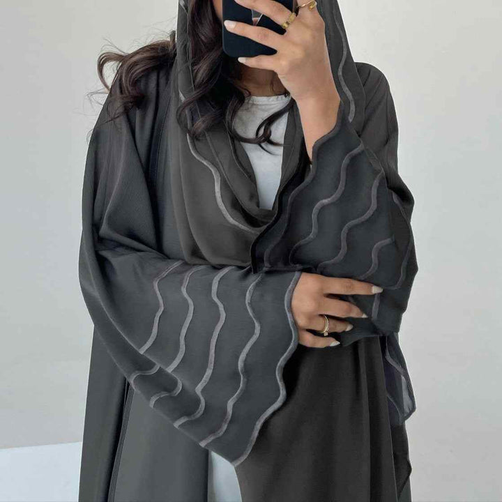 Exquisite abaya with contemporary design and elegant lines, featuring flowing cut and wavy sleeve details.