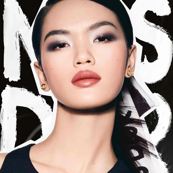 Close-up portrait of a woman wearing Dior Miss Dior makeup with bold eyeshadow and glossy lips, showcasing the limited Fall 2025 collection style.