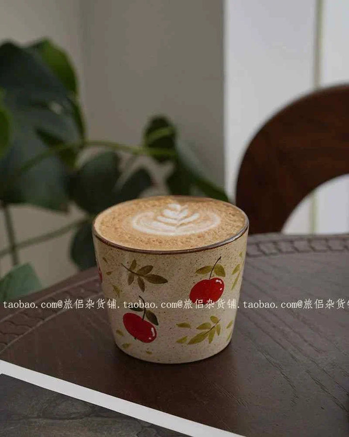Handmade ceramic cup with strawberry and floral design, ideal for coffee or latte.