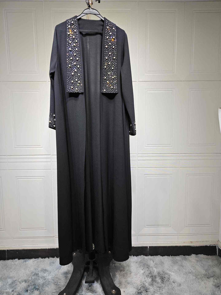 Elegant black abaya with pearl and crystal embellishments on sleeves and collar, perfect for occasions.