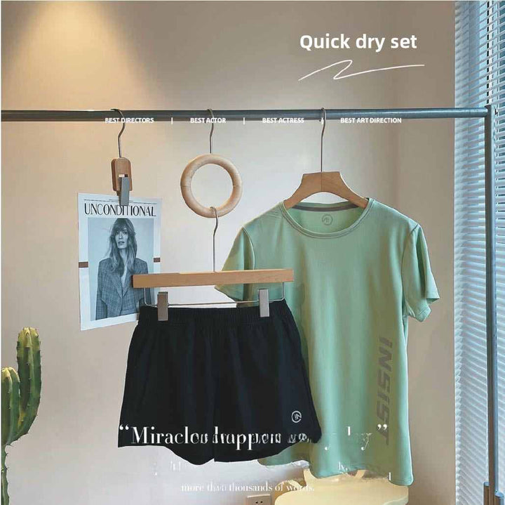 Quick-drying light oxygen exercise suit with green top and black shorts on hangers.