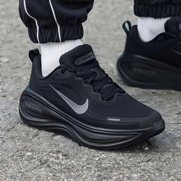 Nike Vomero Plus black running shoes with grey Swoosh, ZoomX cushioning, breathable mesh, and reflective details.