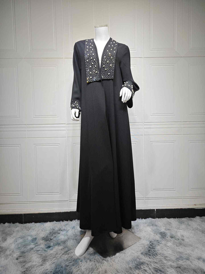 Luxury black abaya adorned with pearls and crystals on sleeves and neckline, perfect for elegant occasions.