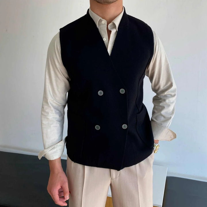 Mr. Lusan's British slim fit wool vest in black with double buttons and side pockets worn over a beige shirt