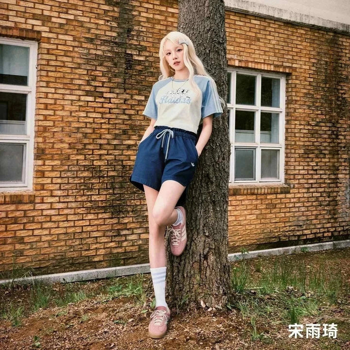 Adidas GAZELLE INDOOR T-Toe classic suede sneakers in pastel pink worn by a woman leaning on a tree outdoors