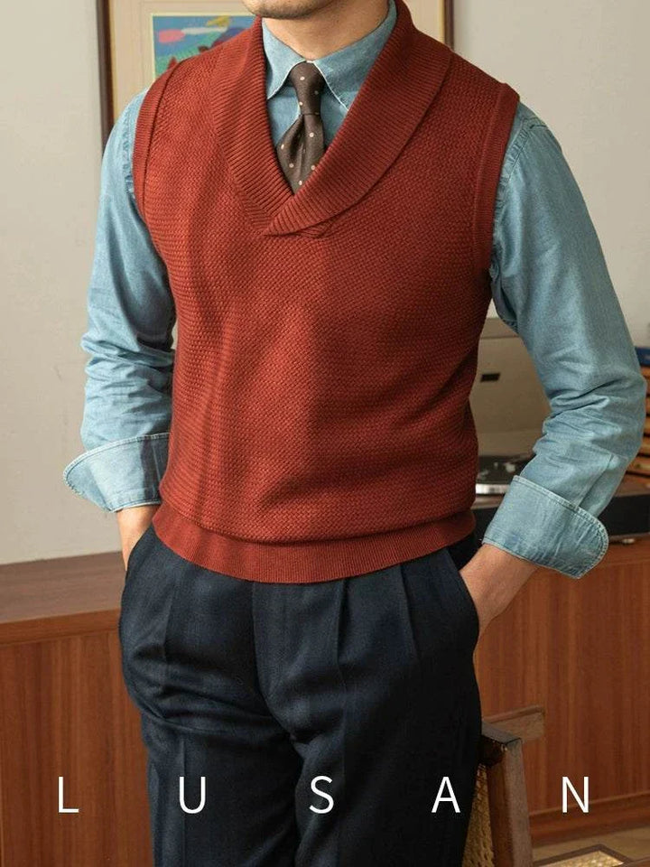 Mr. Lusan warm sweater vest in brick red with shawl collar and fine knit texture, styled over a blue shirt and tie for a classic look