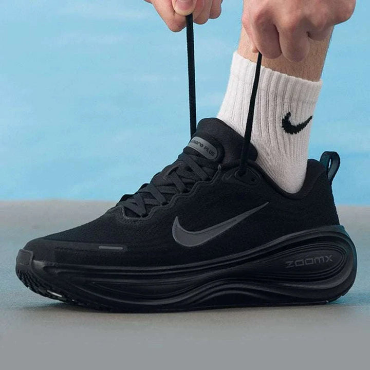Nike Vomero Plus black running shoe with gray swoosh and ZoomX sole being laced up on foot