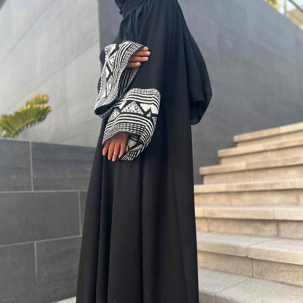 Elegant black abaya with wide sleeves featuring geometric embroidery, suitable for all occasions.