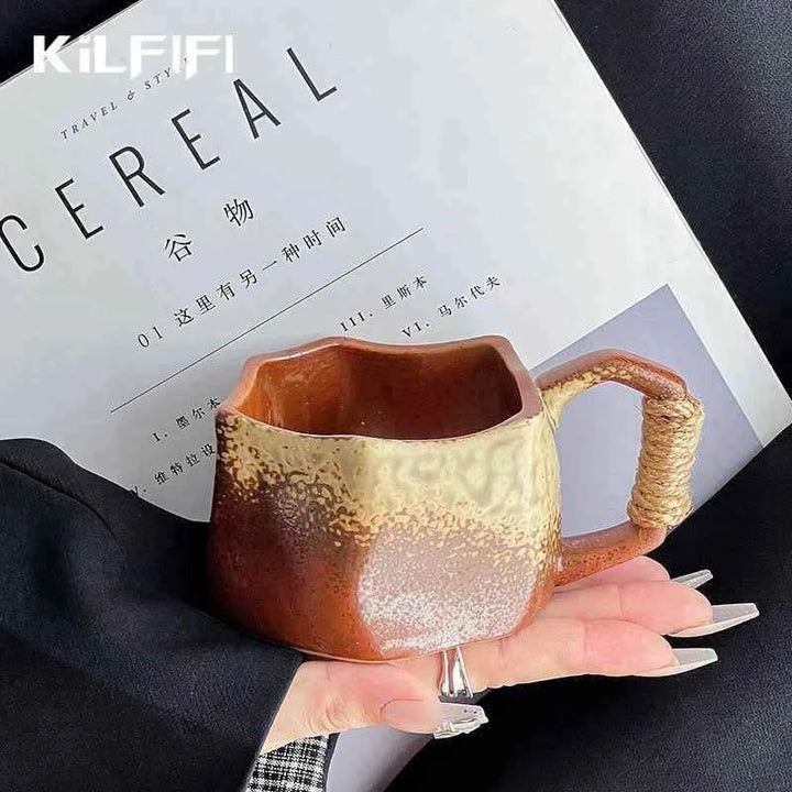 كوب خزفي بني بتصميم عصري على طاولة بجانب مجلة.