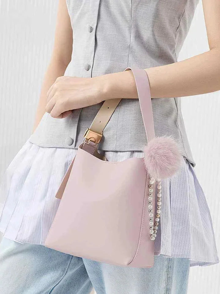 Small pink shoulder bag with faux fur pompom and pearl detail by CHARLES & KEITH