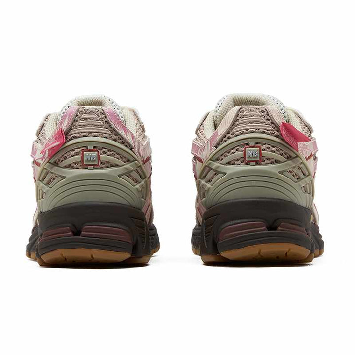 Rear view of New Balance 1906R PandaPrank Limited Edition sneakers in beige, light pink, and dark green with white laces and artistic printed details