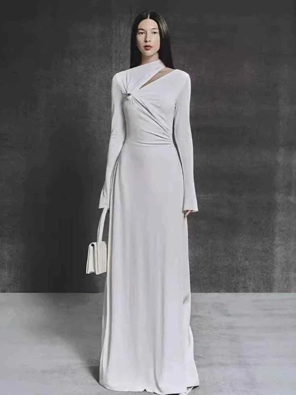 Elegant long sleeve evening maxi dress in soft fabric with a draped waist and silver pin detail.