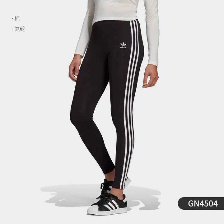 Red Adidas leggings with colorful side stripes, flexible fit, and original Adidas logo, ideal for sports and casual wear