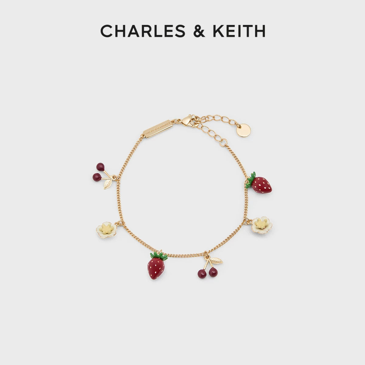 سوار نسائي من Charles & Keith بتصميم الفواكه الذهبي.